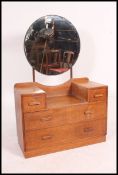 A 1930's Art Deco light oak drop centre dressing table chest of drawers having a circular dressing