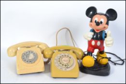 A retro vintage Mickey Mouse telephone together with a mustard coloured BT ring dial telephone and