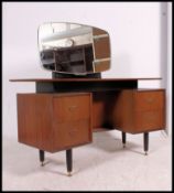 A 1970's G-Plan tola wood dressing table raised on turned legs with pedestal banks of drawers,