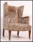 A vintage Edwardian wingback fireside armchair having the original fabric being horse hair stuffed