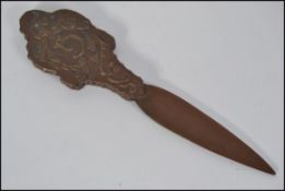 A 20th century bronze letter opener having a foliate and bird handle raised in relief.