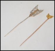 2 9ct gold stick pins, one with diamond inset arrow head, the other with fox head mount.