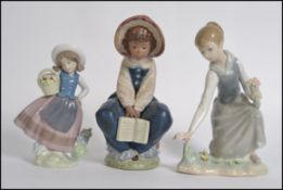 A collection of three Lladro porcelain figures to include a Lladro Daisa figure of a young girl