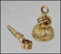 An unmarked fob watch winding key tests 15ct gold with pierced decoration together with a white