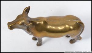 A good 19th century Indian brass figurine of a cow having central seam with the back leg stamped `B.