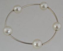 A white metal and pearl bracelet strung