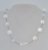A white metal necklace set with baroque
