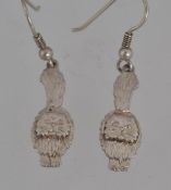 A pair of white metal drop earrings with