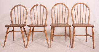 A set of 4 1970's Ercol golden dawn stick back dining chairs in beech and elm with saddle seats and