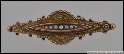 A Victorian hallmarked 9ct gold bar hair locket brooch set with seed pearls surrounded by