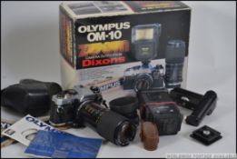 An original Olympus OM-10 together with lens in the original box