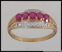 A hallmarked 9ct gold ring with central oval cut red stones in a prong setting with a diamond set