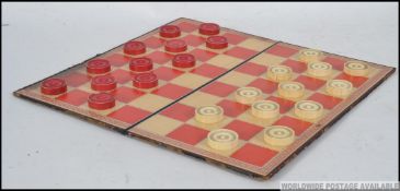 A late 19th century Draught's set with board, the playing pieces being constructed from bone.