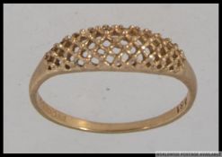 A hallmarked 9ct gold dress ring with woven lattice work dome face with granulated decoration.