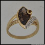 A 9ct gold hallmarked ring set with a large marquise smokey stone with channel set diamonds approx