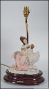 A 20th century Naples ceramic / Capodimonte porcelain table lamp raised on a wooden plinth base.