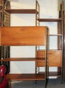 A retro 1970's Ladderax teak modular wall system having metal uprights and bars complete with
