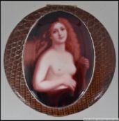 A snakeskin compact with applied enamel pictorial image of a naked red headed women to the case