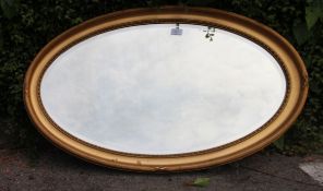 A large Victorian gilded oval mirror, simple moulded detailing to frame.