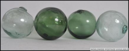 Four 20th century vintage glass fishing floats, two green along with two others. Measures: 13cm.