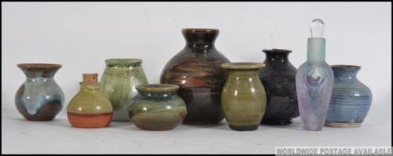 Mixed lot of small studio vases and pots in basket. Many marked to base.