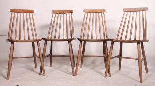 A set of 4 retro Ercol style stick back dining chairs with saddle seats raised on turned legs