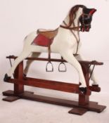 An early 20th century large wooden rocking horse raised on glider in the manner of Lines.
