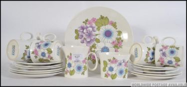 A Retro floral patterned 6 person service by Angelique comprising of cups, saucers,creamer ,