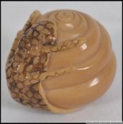 A Chinese hardwood carving of a salamander clinging to a spiral shell.