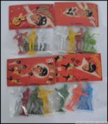 A collection of four packs of four small Beatles figures in coloured plastic entitled 