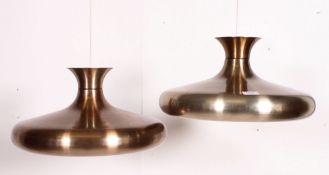 A pair of polished metal retro 20th century conical pendant lamp shades of modernist form.