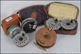 A collection of vin tage fishing reels six in total, to include wooden and alloy,