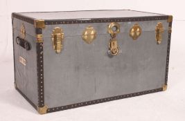 A vintage 20th century grey steamer trunk with brass effect clasps, hinged top with lined interior.