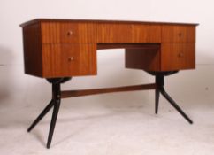 A fantastic 1970's retro teak wood writing table desk raised on sputnik angular ebonised supports
