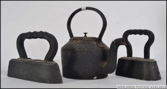 A pair of 19th century Victorian cast iron flat irons along with a 19th century cast iron kettle.