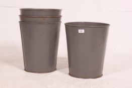 A collection of 4x military issue grey painted metal fire buckets / bins.