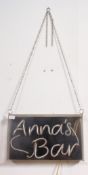 A retro neon light advertising sign for ' Anna's Bar ' in working order within a perspex box.