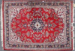A 20th century Islamic fine machine woven rug having red ground with central medallion
