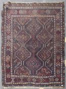 An early 20th century Persian rug with central medallion design on red, blue and black ground.