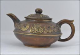 A good Chinese brass yi-xing teapot complete with the lid having embellished coin and character