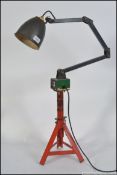 An industrial MEMLITE work lamp top converted into a table lamp by means of having a car jack base