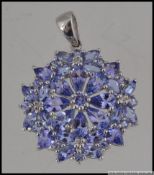 A 9ct white gold pendant set with tanzanite and diamonds in a cluster flower setting. Measures 3cms.