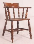 A Victorian beech and elm smokers bow windsor armchair being raised on turned legs united by