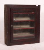 A Victorian mahogany wall mounted shop display cabinet having single door with shelved interior.