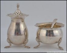 A silver hallmarked pepper pot and matching table salt by George Nathan & Ridley Hayes,