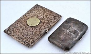 A rococo chased silver hallmarked cigarette case with plain cartouche roundel together with a