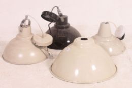A collection of four contemporary retro style metal factory type pendant light fixtures,