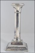 A silver hallmarked column candle stick raised on a square base having worn marks 209g Measures: