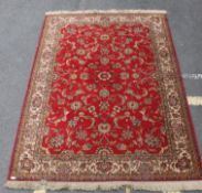 A large French Persian rug having red ground with geometric borders having label to verso for