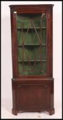 A Georgian mahogany corner cabinet having astragal glazed door cabinet over cupboard beneath.